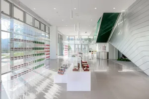 Modern, minimalist retail store with glass walls and steel accents, featuring a clean, uncluttered aesthetic.