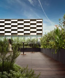 Modern apartment building exterior featuring metal leaves and concrete surfaces.