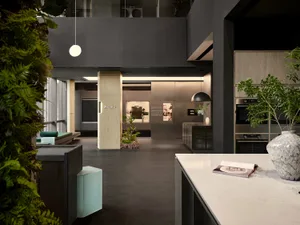 A modern kitchen features marble countertops and a minimalist design with a mix of materials.