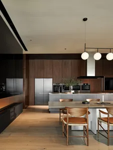 A modern kitchen featuring wooden cabinets, stainless steel appliances, and a concrete countertop.