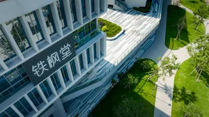 Modern office building with glass walls, concrete exterior, and greenery