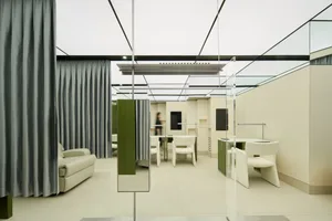 Modern minimalist office interior featuring glass walls and white furniture.