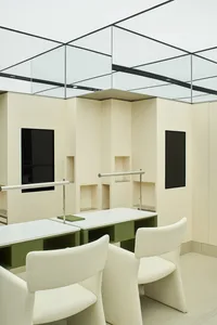 A minimalist office space with white furniture, walls, and tables.