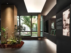 An indoor exhibit space featuring a modern design with concrete, glass, and steel materials.