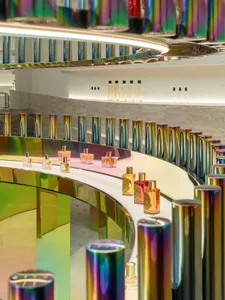 A colorful perfume counter with reflective surfaces and metallic elements.