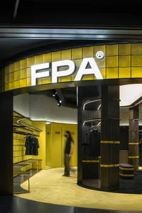 The exterior of a FPA storefront featuring glass tiles and steel columns.