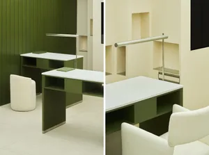 A modern green desk space with a white tabletop and a white upholstered chair.