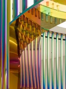 A minimalist glass interior design featuring elongated, colorful glass panels and metal supports.