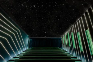 A modern cinema with concrete walls and neon lighting features.