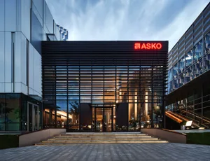 Modern industrial-style office building with glass windows and a metal frame.