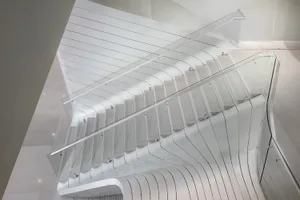 Modern, minimalist staircase with glass railings and steps.