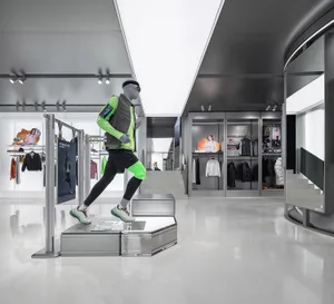 A modern sports shop interior with glass walls, metallic accents, and reflective surfaces.