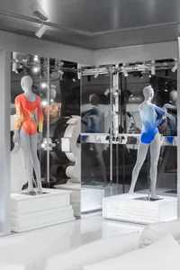 Retail display featuring mannequins wearing outfits encased in glass.