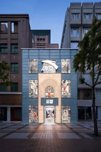A modern retail storefront with glass display windows, brick facade, and lighting features on a city alley.