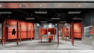 An industrial-style clothing retail shop with metallic shelving units and black flooring.