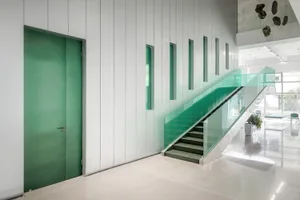 Interior view of a modern office space featuring glass walls and concrete steps.