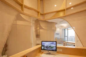 A modern workspace featuring wooden elements and a computer monitor displaying a serene natural scene.