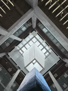 A modern office lobby features sleek glass and concrete materials, creating an open and airy atmosphere.