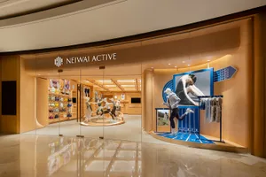 現代零售空間採用木質飾面，搭配運動服飾店面展示，陳列穿著運動服的模特兒