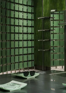 Modern retail space featuring green paneled walls and concrete furniture