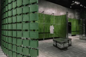 A retail storefront featuring a wall of green metallic panels.
