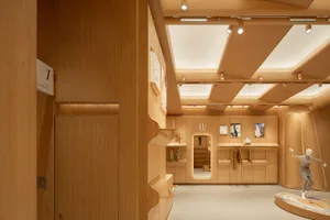 現代展示間擁有木質牆面與天花板，中央擺放一座人台模特兒。