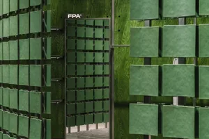Modern storefront featuring glass panels on a green wooden exterior