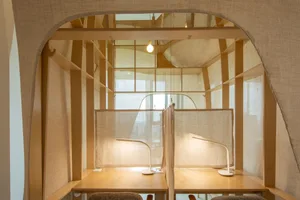 Modern study area with textile dividers and white desk lamps.