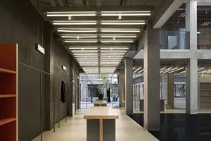 Interior design featuring concrete walls and wood tables in an industrial setting