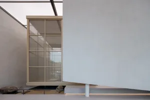 A minimalist interior featuring concrete walls and a glass structure.