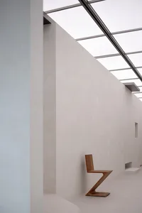 A modern, minimalist concrete lobby with geometric furniture and natural light.