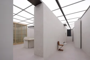 Photograph of a minimalist interior with concrete and glass walls.