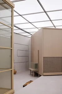 Modern minimalist office cube interior with glass, aluminum, and concrete materials.
