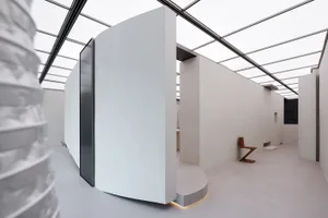 Modern minimalist interior design featuring concrete walls and minimalist furniture under a glass roof.