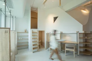 Modern office space with wooden furniture and shelves.