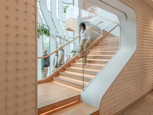 A modern retail space featuring a wooden staircase with glass railings and metal accents.