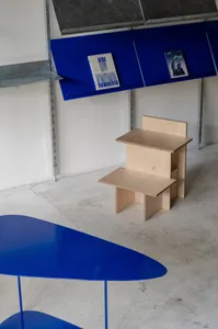 A modern, industrial-style interior design featuring a metal shelving unit with blue elements