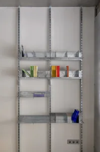 A metal shelf unit with various books and items placed on it.