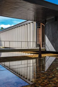 A modern architectural design featuring concrete materials and open spaces.