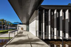 Modern building facade with concrete panels and large windows.