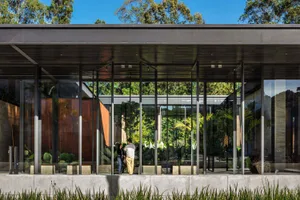 Modern residential entry featuring glass walls and concrete floor.