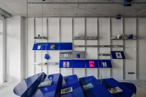 A modern library with blue metallic shelves and various books displayed on it.