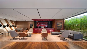 A modern loft with an industrial bar area featuring wood flooring, glass bar counter, and metal accents.