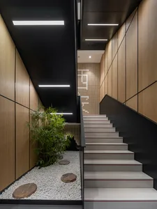 A modern interior staircase with concrete steps and steel handrail, featuring a minimalist design.