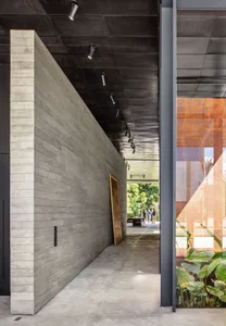 Concrete lobby interior with exposed brick walls and industrial lighting.