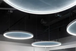 Circular metallic lighting fixtures in a minimalist office environment.