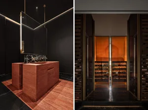 Modern bathroom with a red marble density cube sink and black walls.