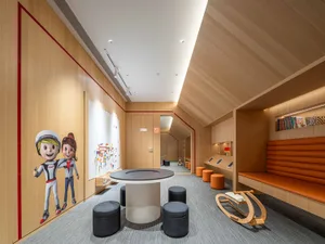 A modern children's playroom with a wooden wall, a black and white circular table, orange and blue fabric seating options, pl