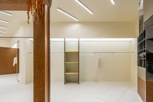 Modern closet with white-paneled walls and yellow shelves.