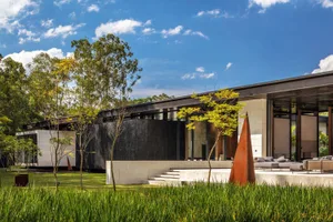 A modern exterior featuring black glass, concrete, and metal elements.